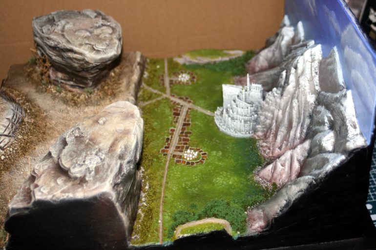 Finally, I gave the impression of trees and vegetation to the middle-ground using some types of flock.  If you look closely I also place some fir trees along the mountain edges.