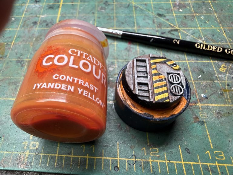 Use GW Iyanden Yellow to cover the white areas. Et voila, hazard stripes! Necromunda is so much safer thanks to you...